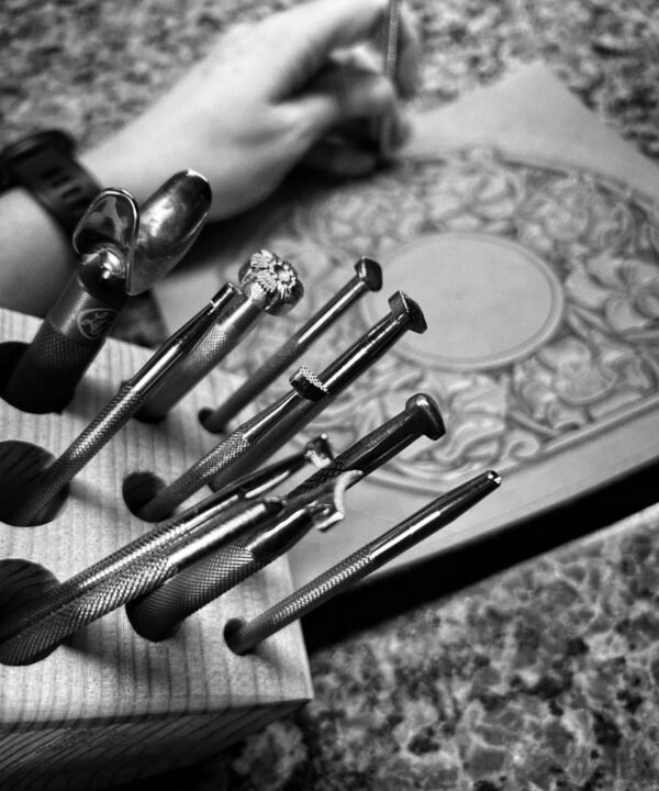 Leather carving with tools in foreground.