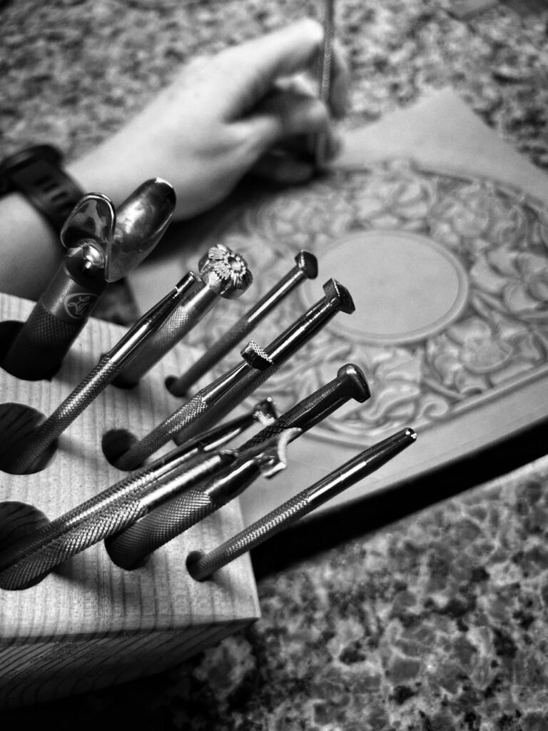 Leather carving with tools in foreground.