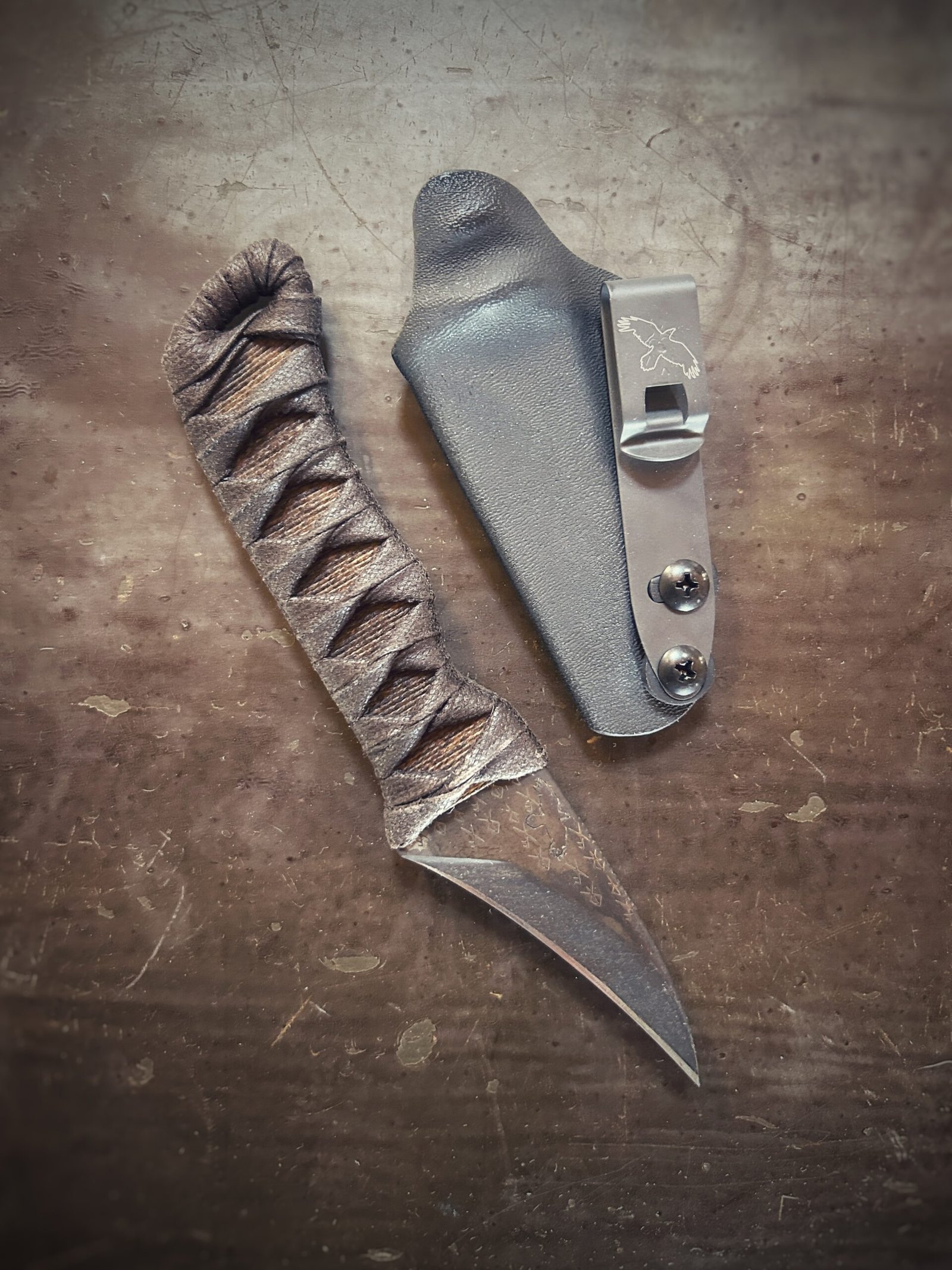 Corax with natural heat treat and brown wrap over burnt jute out of sheath. Runes etched into blade.