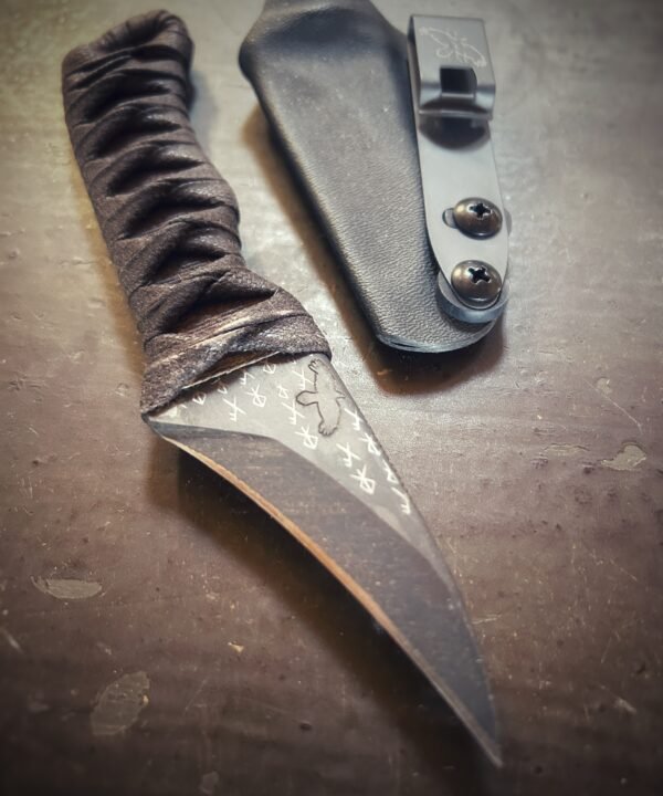 Corax with natural heat treat and brown wrap over burnt jute out of sheath. Runes etched into blade.