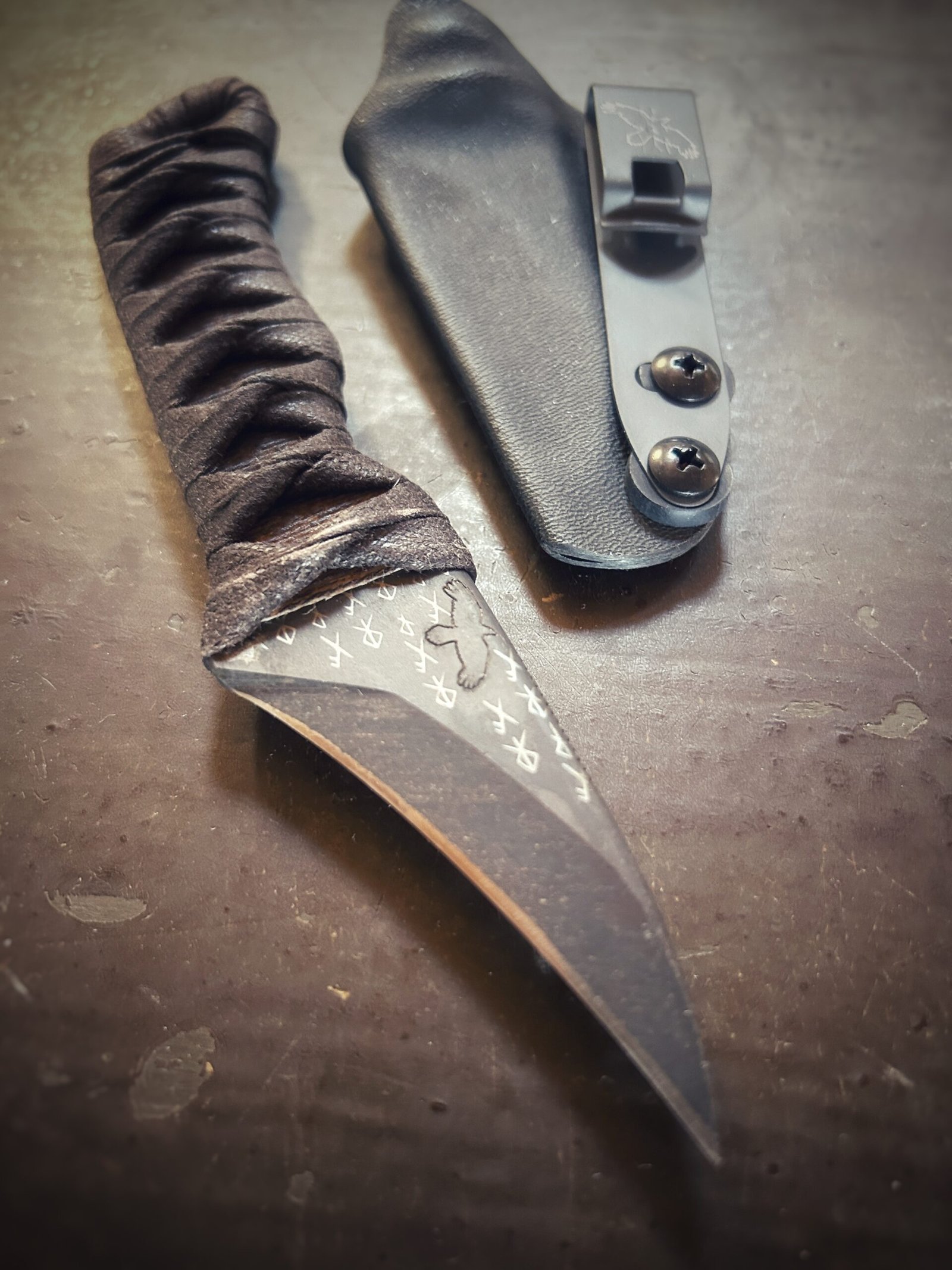 Corax with natural heat treat and brown wrap over burnt jute out of sheath. Runes etched into blade.