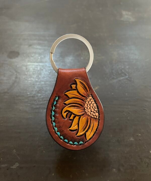 Carved AirTag Fob with brown background and carved sunflower