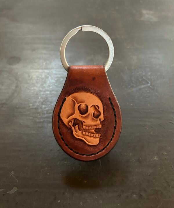Carved AirTag Fob with brown background and carved skull