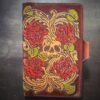 Notebook with 4 roses and a skull in a Western floral design on a brown background