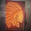Notebook with an skull in a head dress on a brown background