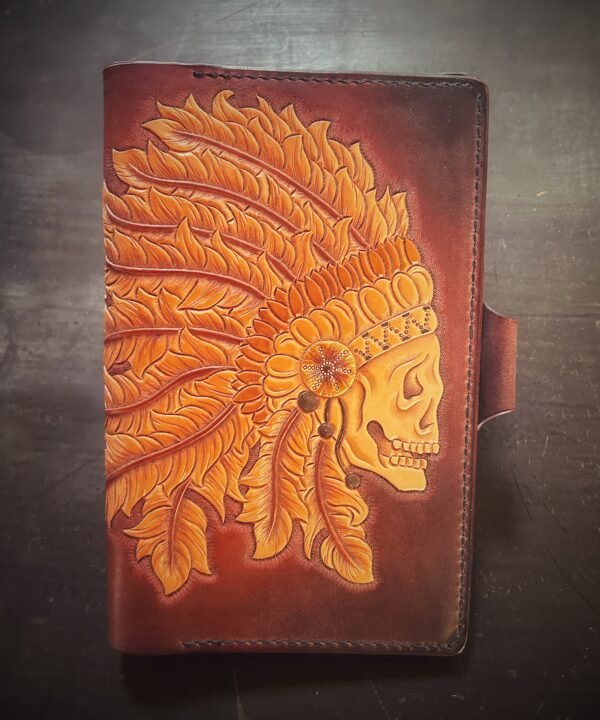 Notebook with an skull in a head dress on a brown background