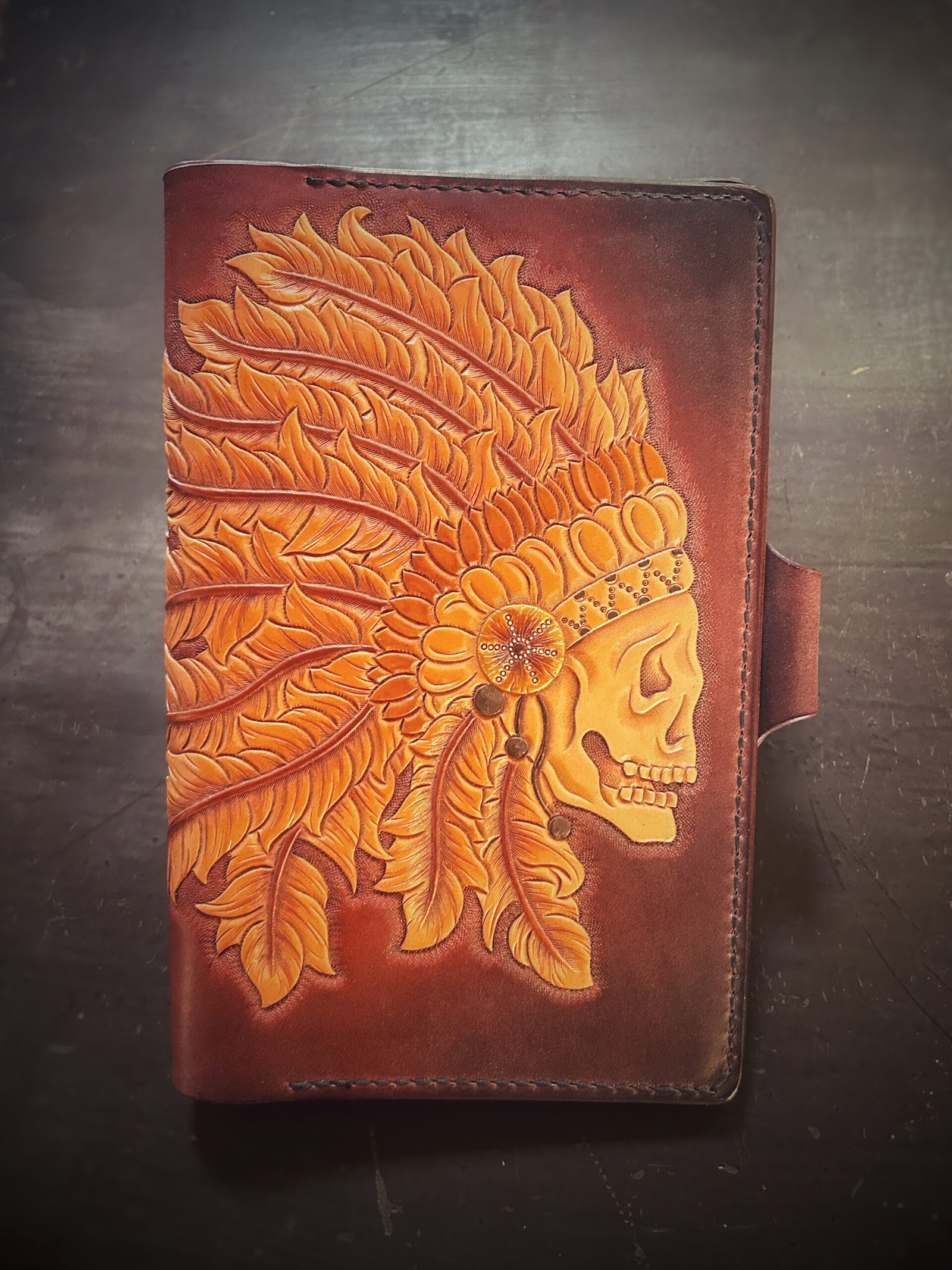 Notebook with an skull in a head dress on a brown background