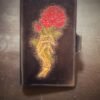 Notebook with 2 roses in a skeleton hand on a black background