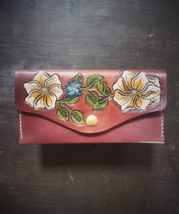 Madison wallet exterior, with 2 cream and white flowers and one blue and cream smaller flower on a brown background