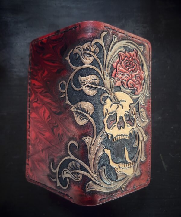 Boulder wallet exterior, red and black marbled background with skull, rose, western scroll work on right side