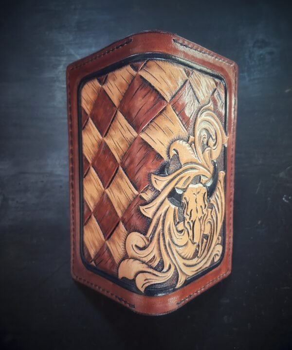 Boulder wallet exterior, brown and tan basketweave background and black boarder. Western scroll and cow skull in lower right corner.