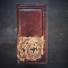 Boulder wallet exterior, brown and black marbled background with black boarder and oak leaves in lower right corner
